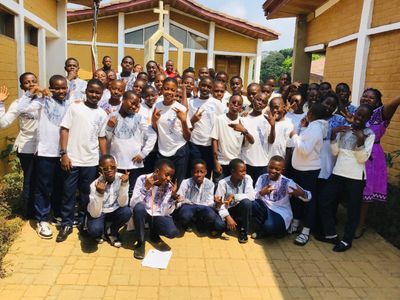A large group of students gathered outside the school buildings