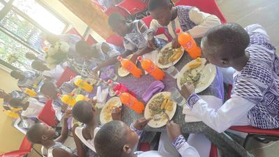 Students sharing a meal around a long table in the refectory