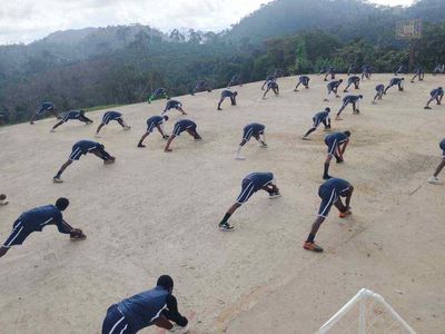 Students stretching in rows on the hilltop court
