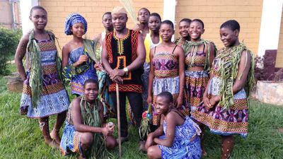 Students in traditional dress with their teacher after a cultural dance performance